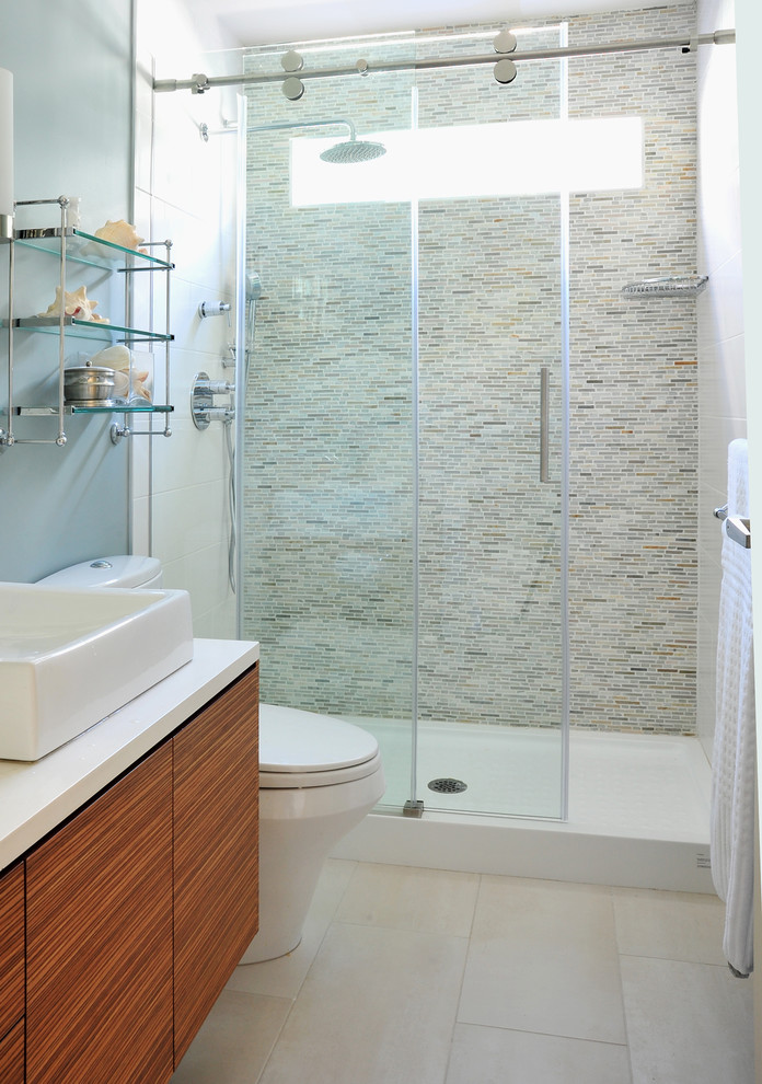 Exemple d'une douche en alcôve tendance en bois brun de taille moyenne avec un placard à porte plane, WC à poser, un mur bleu, un sol en carrelage de porcelaine, une vasque et un plan de toilette en quartz modifié.