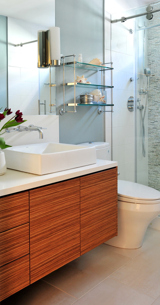 Modern inredning av ett mellanstort badrum, med släta luckor, skåp i mellenmörkt trä, en dusch i en alkov, en toalettstol med hel cisternkåpa, blå väggar, klinkergolv i porslin, ett fristående handfat och bänkskiva i kvarts