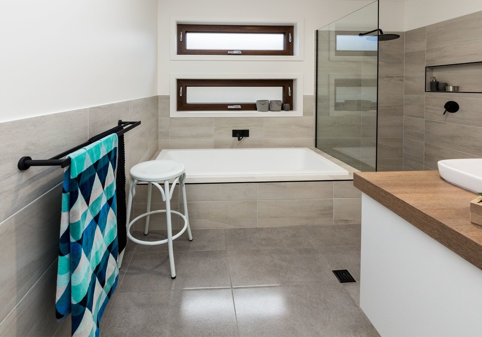 Стильный дизайн: большая детская ванная комната в современном стиле с плоскими фасадами, белыми фасадами, накладной ванной, открытым душем, серой плиткой, керамической плиткой, белыми стенами, полом из керамогранита, настольной раковиной, столешницей из ламината, серым полом и открытым душем - последний тренд