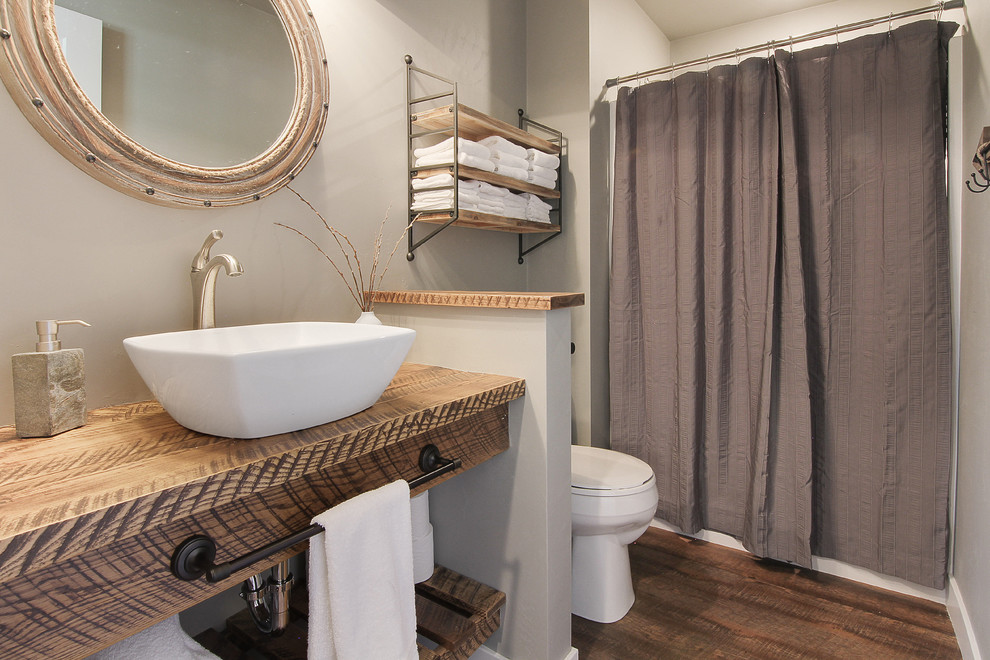 Immagine di una stanza da bagno country con doccia alcova, pareti grigie, parquet scuro, lavabo a bacinella, top in legno, pavimento marrone, doccia con tenda e top marrone