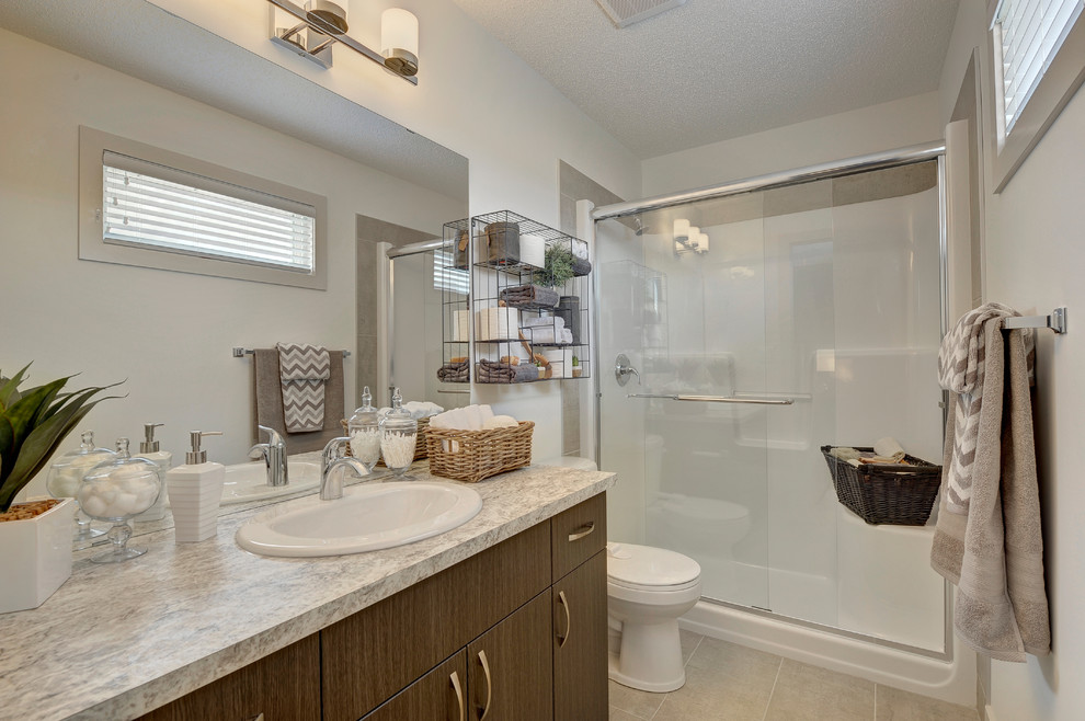 Photo of a medium sized classic family bathroom in Edmonton with flat-panel cabinets, black cabinets, an alcove shower, a two-piece toilet, white tiles, ceramic tiles, white walls, ceramic flooring, a built-in sink, laminate worktops, beige floors and a sliding door.