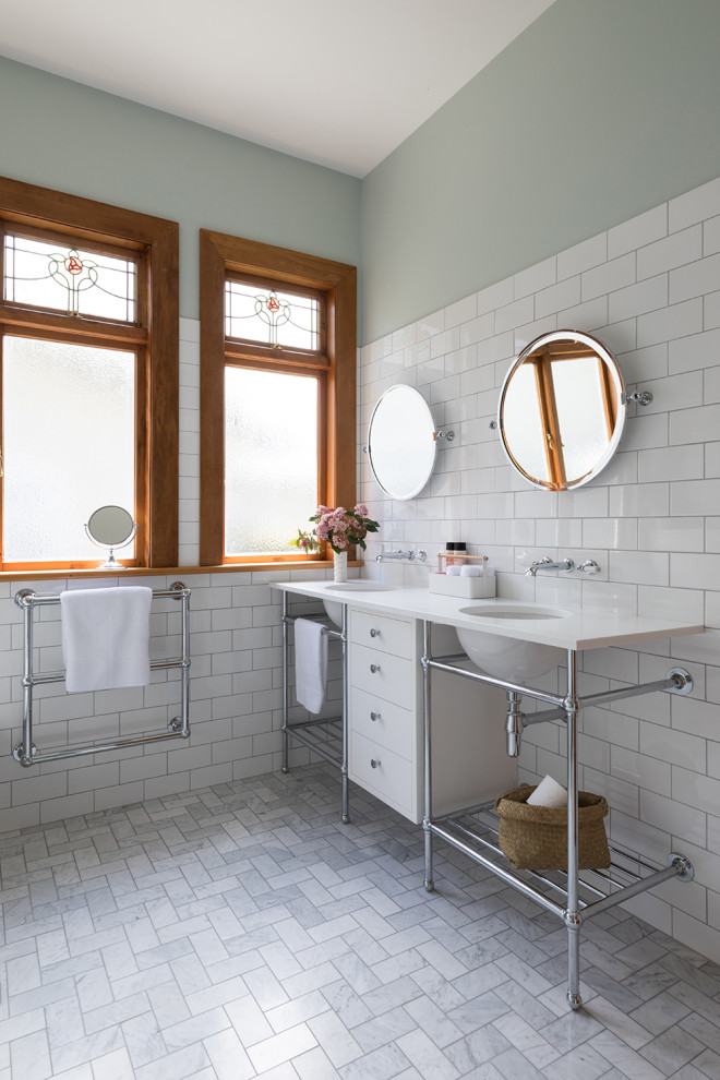 Réalisation d'une salle de bain tradition avec un carrelage blanc, un carrelage métro, un mur vert, un lavabo encastré, un sol gris et un plan de toilette blanc.