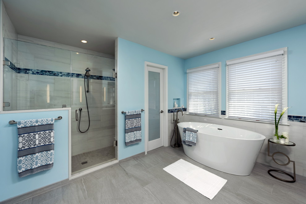 На фото: большая главная ванная комната в стиле неоклассика (современная классика) с фасадами с утопленной филенкой, серыми фасадами, отдельно стоящей ванной, душем в нише, раздельным унитазом, белой плиткой, мраморной плиткой, синими стенами, полом из керамогранита, врезной раковиной, столешницей из кварцита, серым полом, душем с распашными дверями и белой столешницей