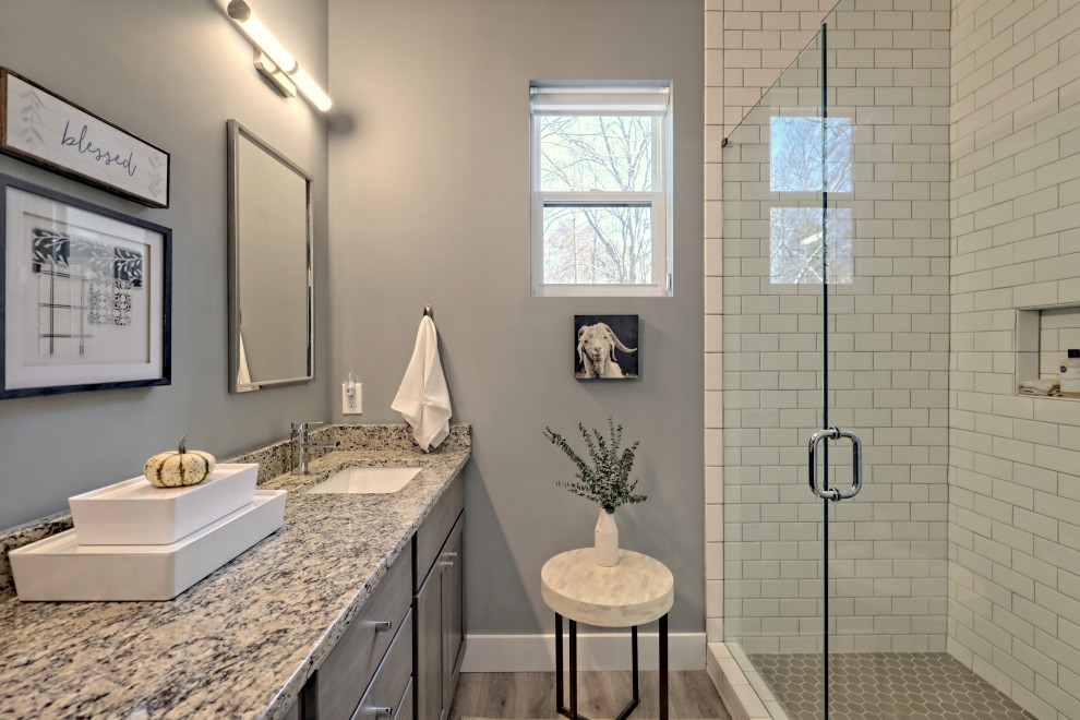 Diseño de cuarto de baño principal de estilo de casa de campo pequeño con armarios estilo shaker, puertas de armario grises, lavabo bajoencimera, encimera de granito y encimeras multicolor