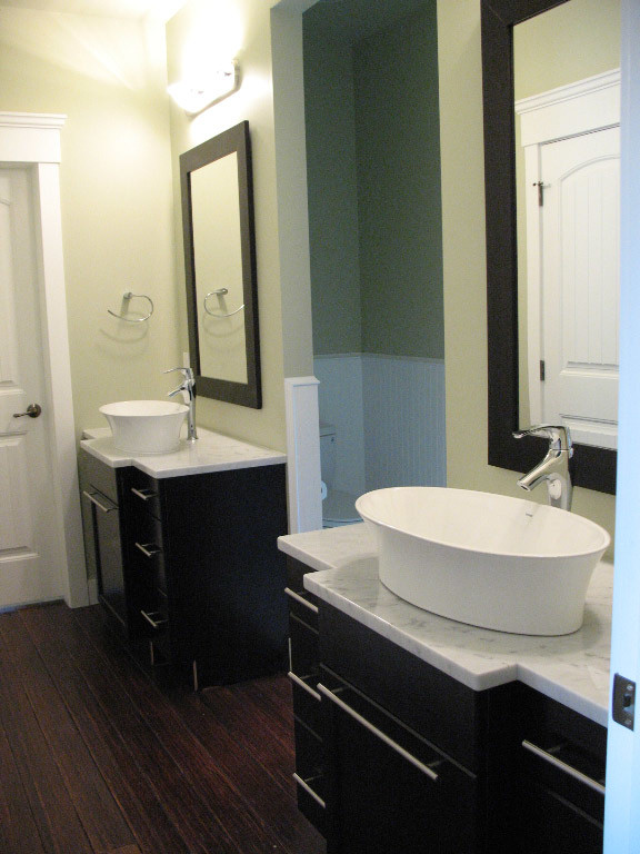 Inspiration för mellanstora moderna en-suite badrum, med släta luckor, skåp i mörkt trä, granitbänkskiva och mörkt trägolv