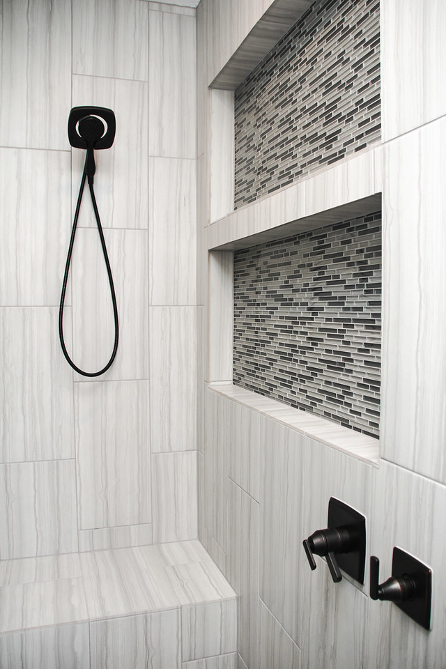 Bild på ett mellanstort funkis en-suite badrum, med luckor med infälld panel, vita skåp, en dubbeldusch, en toalettstol med separat cisternkåpa, grå kakel, porslinskakel, grå väggar, klinkergolv i porslin, ett undermonterad handfat, granitbänkskiva, grått golv och dusch med gångjärnsdörr
