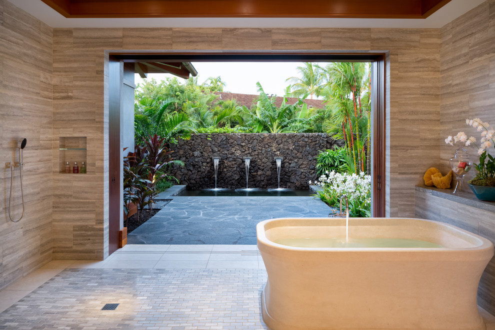 Badezimmer En Suite mit freistehender Badewanne, bodengleicher Dusche und grauen Fliesen in Hawaii