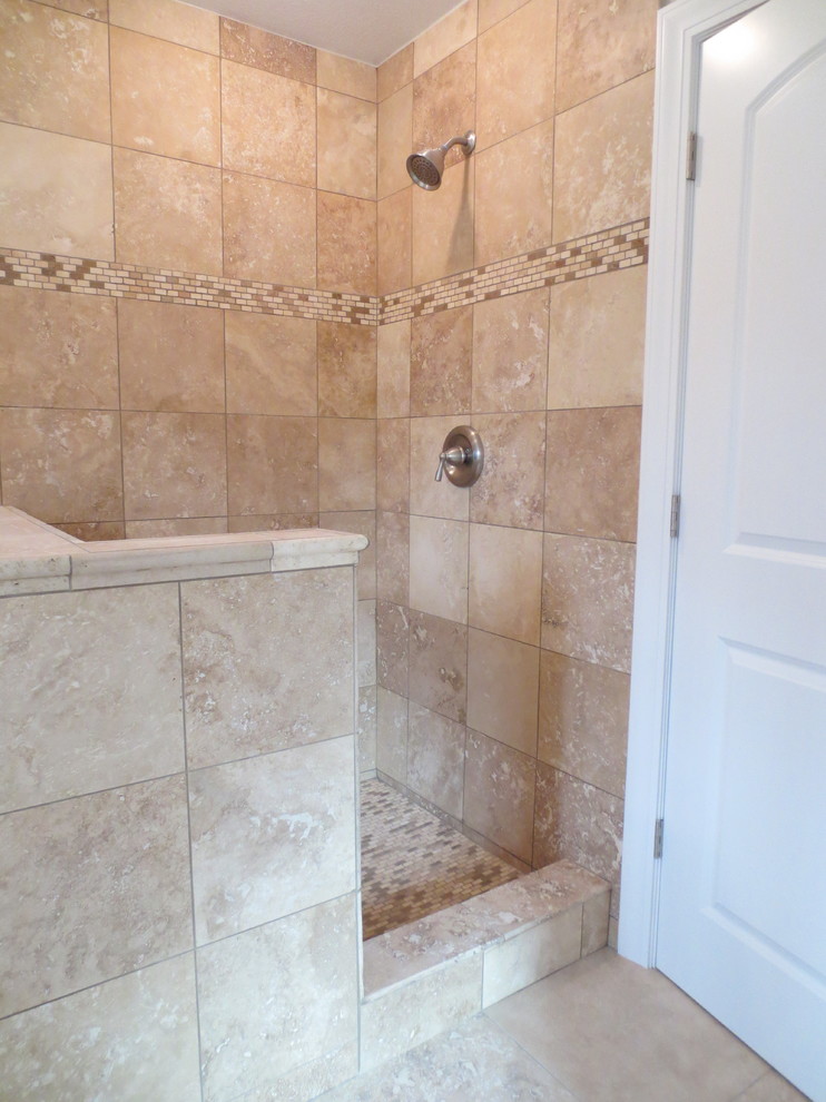 Photo of a medium sized traditional ensuite bathroom in Milwaukee with a submerged sink, flat-panel cabinets, dark wood cabinets, granite worktops, a built-in bath, a walk-in shower, a two-piece toilet, grey tiles, stone tiles, grey walls and travertine flooring.