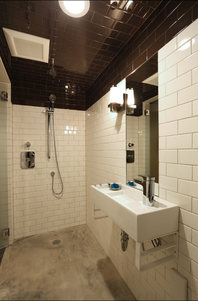 Exempel på ett litet modernt badrum med dusch, med ett väggmonterat handfat, en öppen dusch, en toalettstol med hel cisternkåpa, vit kakel, keramikplattor, vita väggar och betonggolv