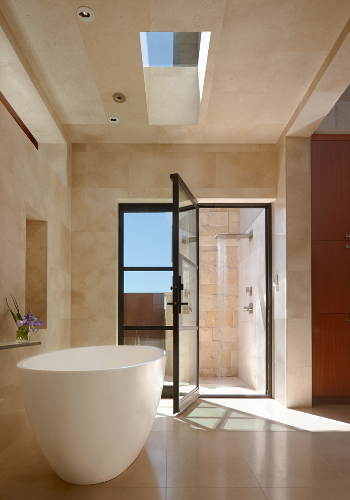 На фото: главная ванная комната в современном стиле с отдельно стоящей ванной, открытым душем, бежевой плиткой, бежевыми стенами и бежевым полом с