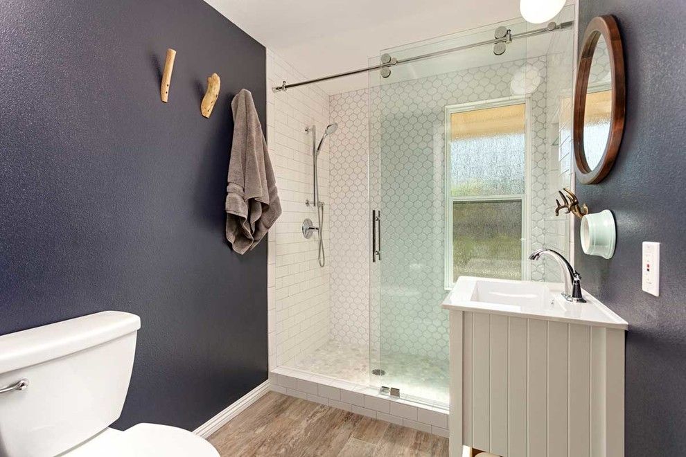 Foto på ett mellanstort funkis vit badrum med dusch, med vita skåp, en toalettstol med separat cisternkåpa, vit kakel, tunnelbanekakel, blå väggar, klinkergolv i porslin, ett nedsänkt handfat, bänkskiva i kvartsit, grått golv och dusch med skjutdörr