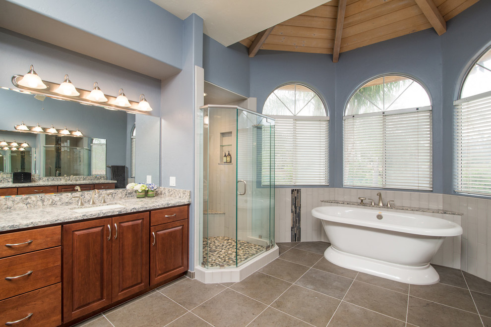 Example of a huge minimalist master gray tile and ceramic tile ceramic tile bathroom design in San Diego with a drop-in sink, raised-panel cabinets, medium tone wood cabinets, granite countertops, a wall-mount toilet and blue walls