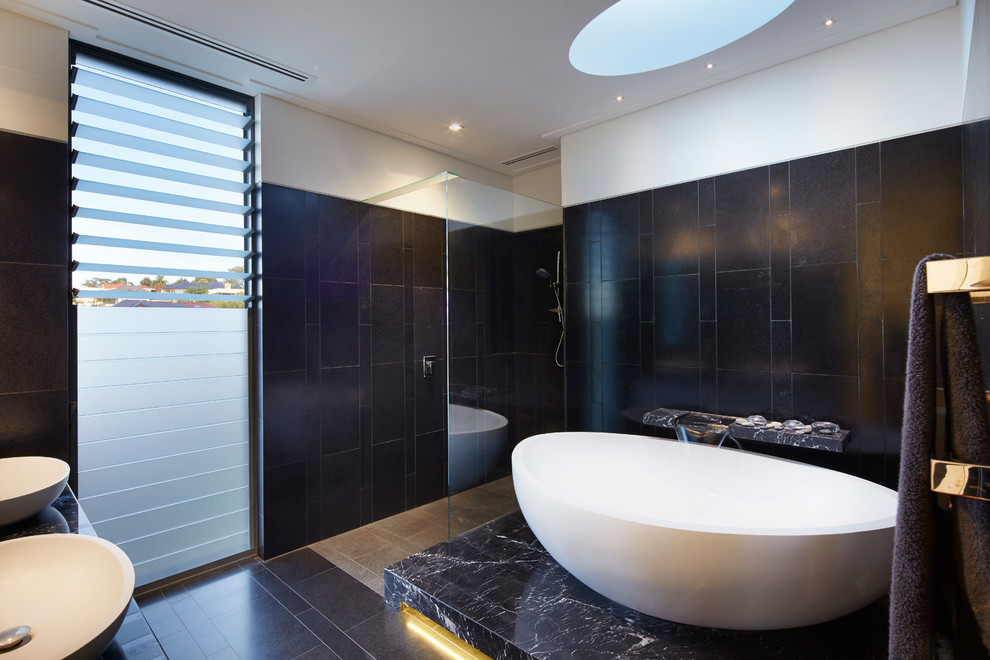 Diseño de cuarto de baño principal actual con lavabo sobreencimera, bañera exenta, ducha a ras de suelo, baldosas y/o azulejos negros, paredes negras y ventanas
