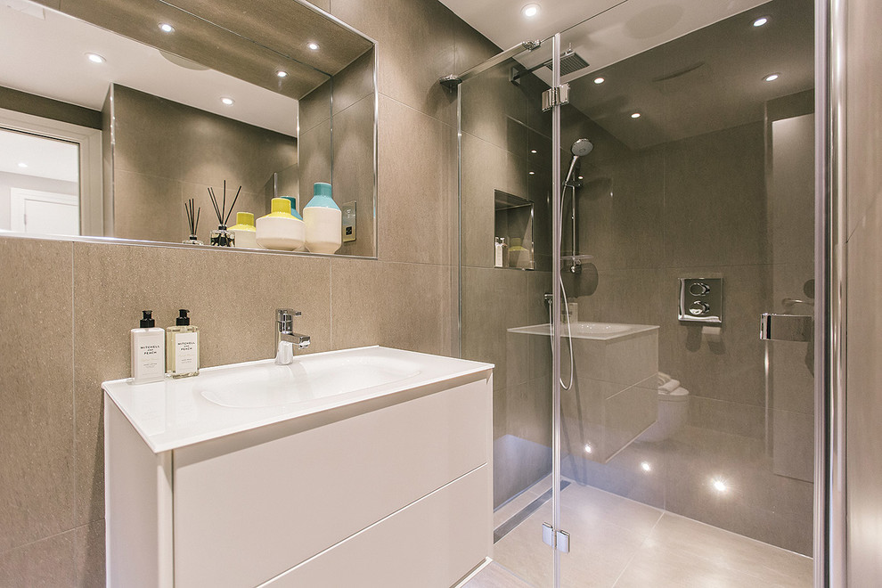 This is an example of a medium sized contemporary family bathroom in London with white cabinets, a built-in bath, a shower/bath combination, a wall mounted toilet, white tiles, porcelain tiles, brown walls, porcelain flooring, a console sink and engineered stone worktops.
