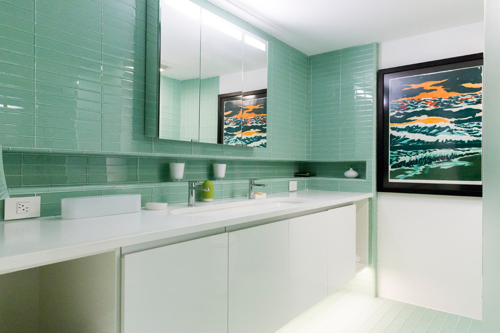Esempio di una stanza da bagno con doccia minimalista con ante lisce, ante bianche, piastrelle verdi, piastrelle di vetro, pareti bianche, pavimento con piastrelle in ceramica, lavabo sottopiano, top in superficie solida, pavimento verde e top bianco