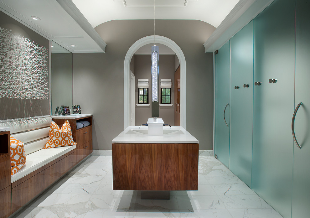 Imagen de cuarto de baño principal actual grande con lavabo integrado, armarios con paneles lisos, puertas de armario de madera oscura, suelo de mármol, encimera de mármol, paredes grises y suelo blanco