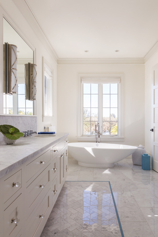 Foto di una stanza da bagno padronale contemporanea con ante in stile shaker, ante bianche, vasca freestanding, pareti bianche, pavimento in marmo, lavabo sottopiano e top in marmo