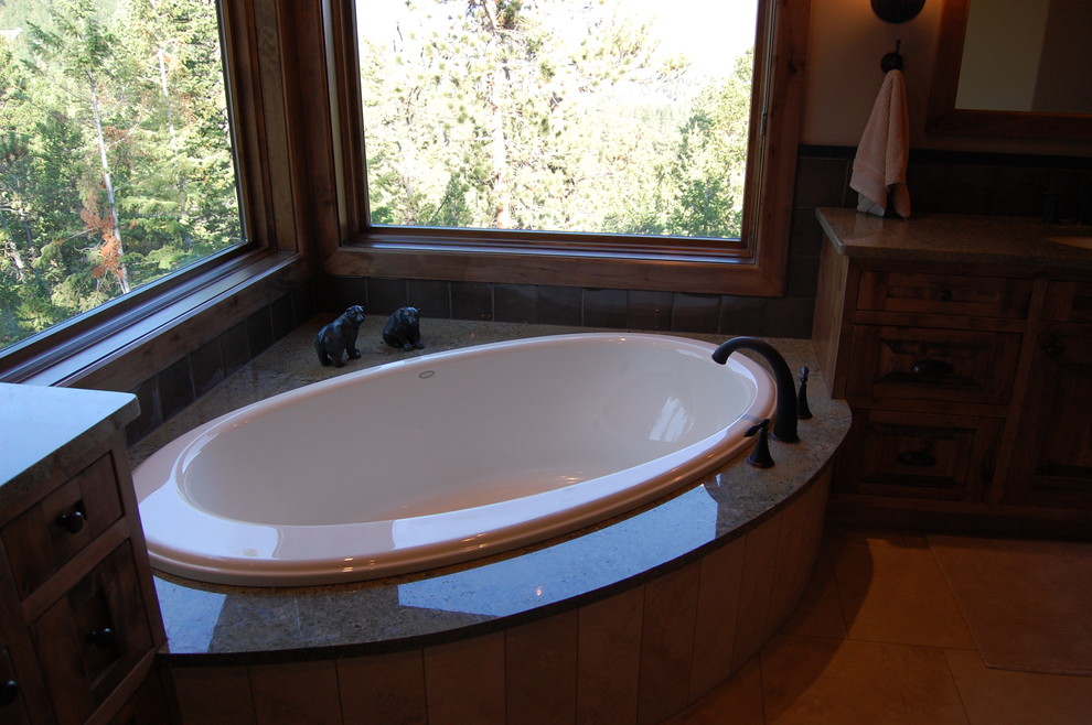 Inspiration pour une grande salle de bain principale chalet avec un plan de toilette en granite et une baignoire d'angle.