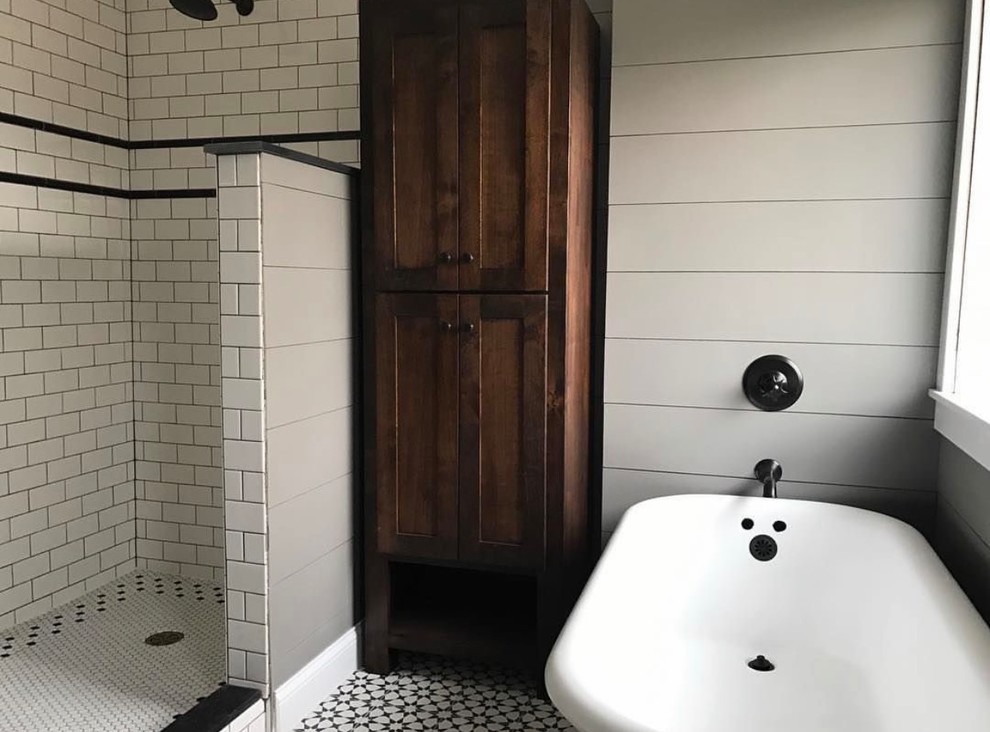 На фото: ванная комната среднего размера в стиле кантри с плоскими фасадами, темными деревянными фасадами, ванной на ножках, белой плиткой, плиткой кабанчик, серыми стенами, полом из цементной плитки, накладной раковиной и разноцветным полом