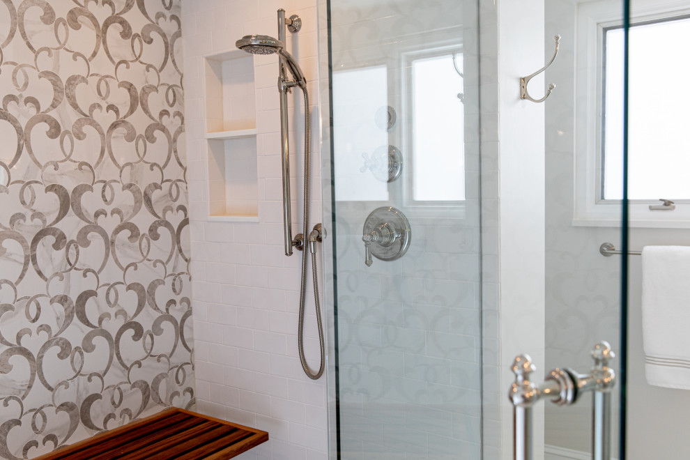 Cette image montre une salle de bain principale traditionnelle avec un placard à porte shaker, un carrelage multicolore, une cabine de douche à porte battante, un plan de toilette blanc, un banc de douche, meuble double vasque et meuble-lavabo encastré.