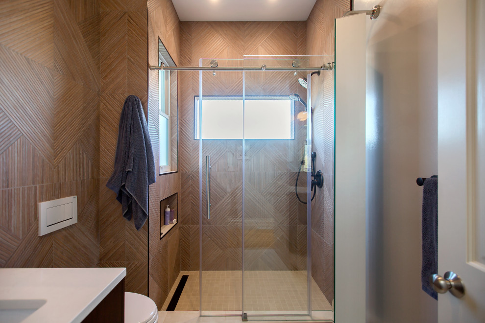 Small traditional ensuite bathroom in San Francisco with freestanding cabinets, brown cabinets, an alcove shower, a wall mounted toilet, brown tiles, porcelain tiles, brown walls, porcelain flooring, a submerged sink, engineered stone worktops, beige floors, a hinged door, white worktops, a wall niche, a single sink and a freestanding vanity unit.