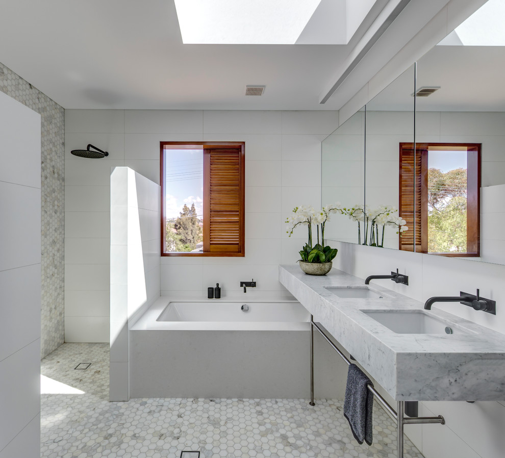 Inspiration pour une grande salle de bain design avec une baignoire encastrée, une douche ouverte, un carrelage gris, un carrelage blanc, un carrelage de pierre, un mur blanc, un lavabo encastré et aucune cabine.