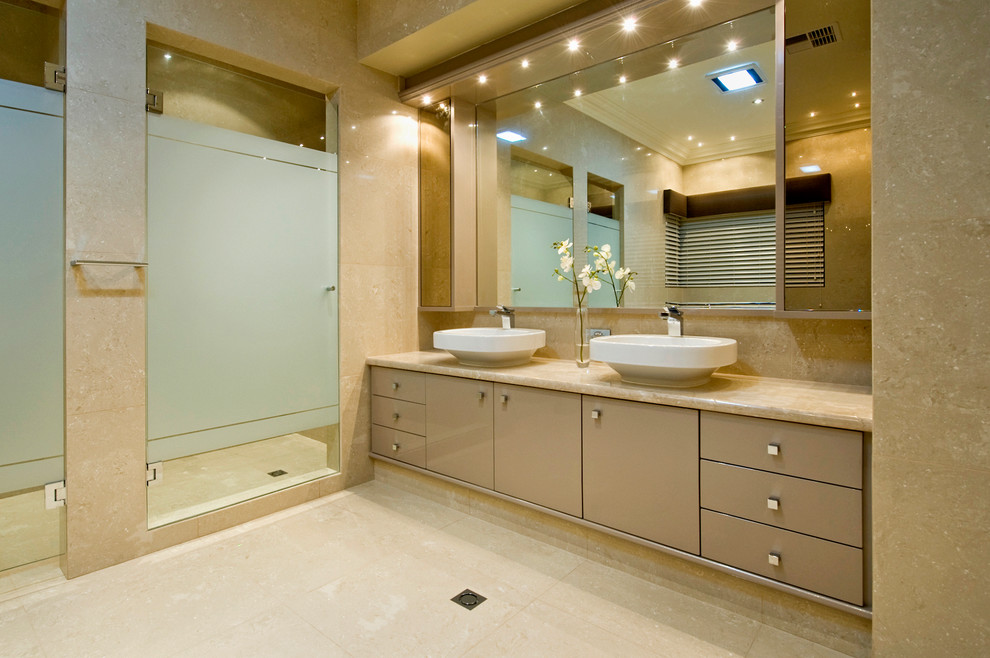 Стильный дизайн: огромная главная ванная комната в современном стиле с настольной раковиной, плоскими фасадами, мраморной столешницей, отдельно стоящей ванной, двойным душем, унитазом-моноблоком, бежевой плиткой, керамогранитной плиткой, бежевыми стенами и полом из керамогранита - последний тренд