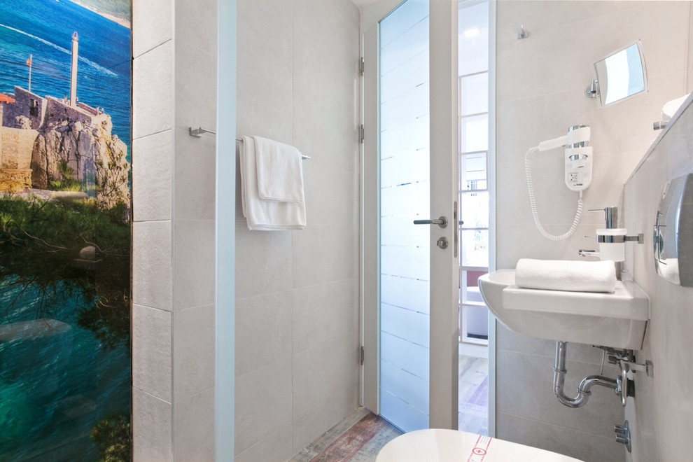 Immagine di una piccola stanza da bagno con doccia stile marinaro con doccia alcova, WC monopezzo e lavabo sospeso