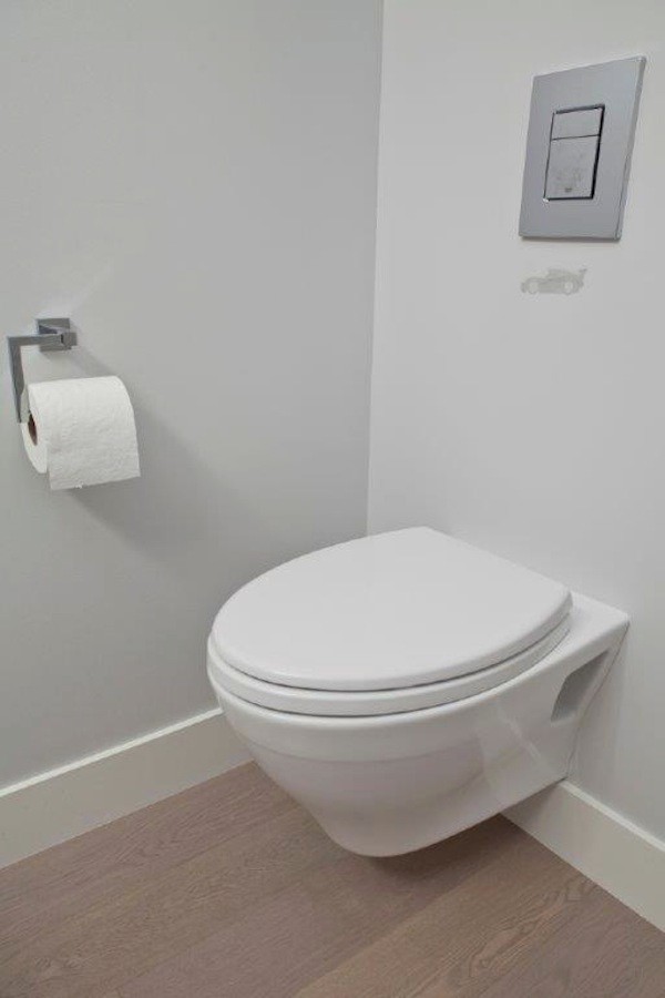 This is an example of a medium sized contemporary ensuite bathroom in Vancouver with a wall mounted toilet, a freestanding bath, a corner shower, grey walls, ceramic flooring, grey floors and a hinged door.