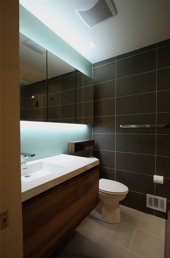 Bild på ett funkis badrum, med ett integrerad handfat och svart kakel