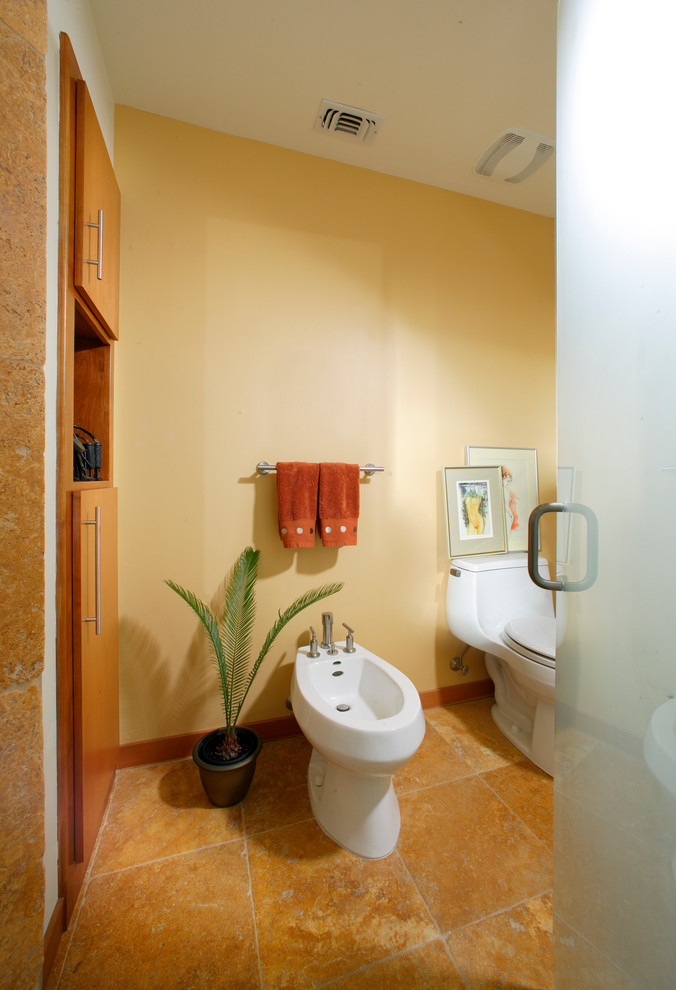 Exemple d'une petite salle de bain principale tendance en bois brun avec un placard à porte plane, un bidet, un carrelage beige, un carrelage de pierre, un mur beige, un sol en travertin, une vasque et un plan de toilette en stéatite.