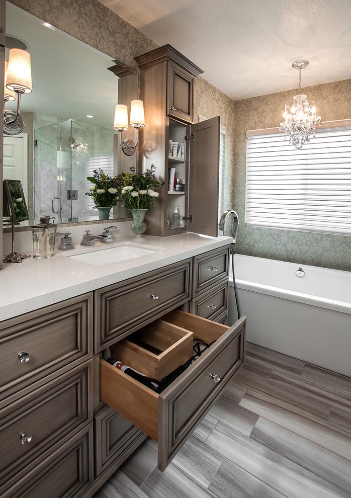 This is an example of a medium sized traditional ensuite bathroom in Orange County with a submerged sink, recessed-panel cabinets, grey cabinets, engineered stone worktops, a freestanding bath, multi-coloured walls and porcelain flooring.