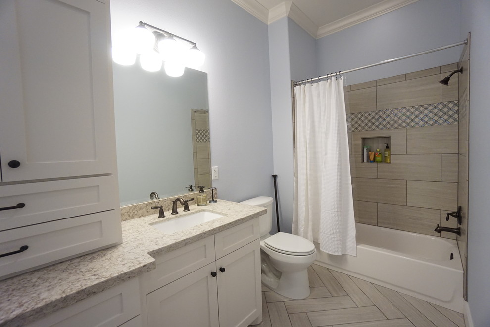 На фото: детская ванная комната среднего размера в морском стиле с врезной раковиной, фасадами в стиле шейкер, белыми фасадами, столешницей из гранита, раздельным унитазом, серой плиткой, полом из керамогранита, ванной в нише, душем над ванной, керамической плиткой и синими стенами