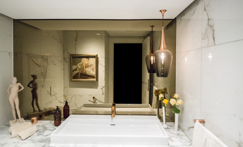 Idée de décoration pour une salle de bain design avec WC suspendus, un carrelage blanc, un mur blanc, un lavabo posé et un plan de toilette blanc.