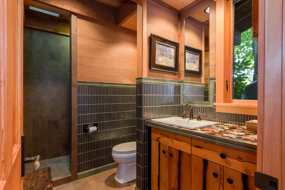 Ejemplo de cuarto de baño rural grande con lavabo encastrado, puertas de armario de madera oscura, encimera de azulejos, ducha empotrada y aseo y ducha