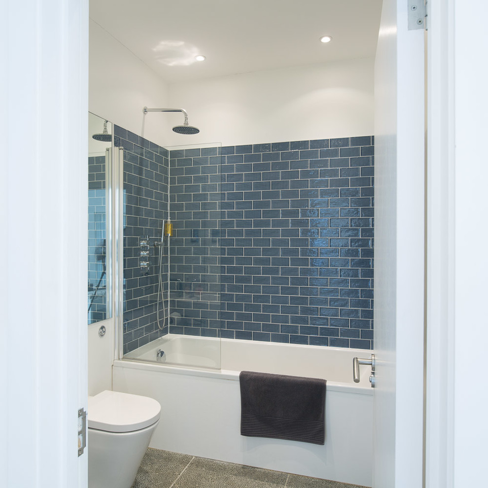 Exemple d'une petite salle de bain moderne avec un bain bouillonnant, un combiné douche/baignoire, un carrelage gris et un sol en carrelage de céramique.