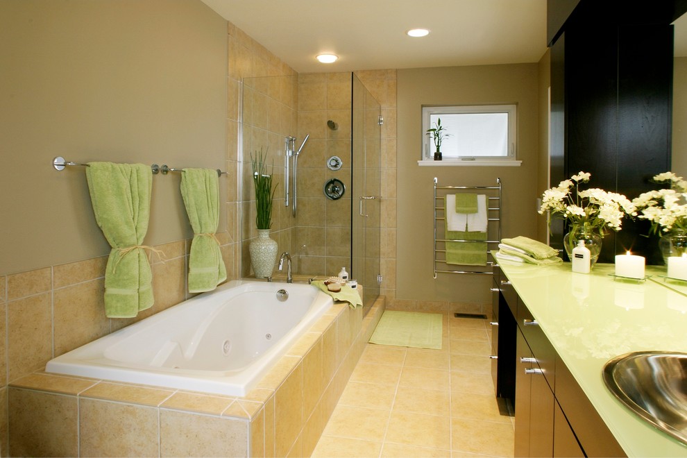 Immagine di una stanza da bagno classica con lavabo da incasso, ante lisce, ante in legno bruno, top in vetro, vasca idromassaggio, doccia ad angolo, WC a due pezzi, piastrelle beige e piastrelle in ceramica