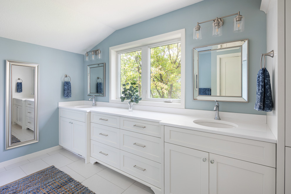 Exemple d'une grande salle de bain principale bord de mer avec des portes de placard blanches, un mur bleu, un lavabo encastré, un plan de toilette en quartz modifié, un plan de toilette blanc, un placard à porte shaker, un sol blanc, meuble double vasque et meuble-lavabo encastré.