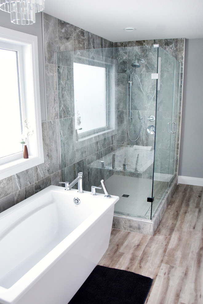 Diseño de cuarto de baño principal contemporáneo de tamaño medio con paredes grises, suelo de madera en tonos medios, bañera exenta y ducha empotrada