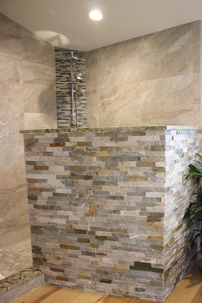 Large world-inspired ensuite bathroom in Tampa with flat-panel cabinets, dark wood cabinets, a freestanding bath, a corner shower, a two-piece toilet, beige tiles, brown tiles, grey tiles, multi-coloured tiles, stone tiles, grey walls, light hardwood flooring, a vessel sink and granite worktops.