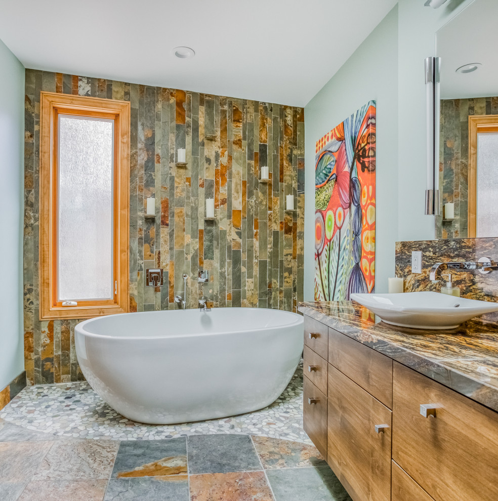 Modernes Badezimmer mit flächenbündigen Schrankfronten, hellbraunen Holzschränken, freistehender Badewanne, grünen Fliesen, blauer Wandfarbe, Aufsatzwaschbecken, buntem Boden und brauner Waschtischplatte in San Diego