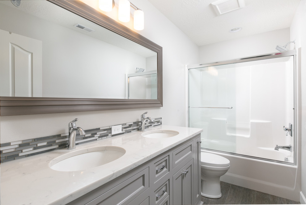 Design ideas for a medium sized traditional family bathroom in Portland with grey cabinets, a shower/bath combination, grey tiles, white walls, medium hardwood flooring and a submerged sink.