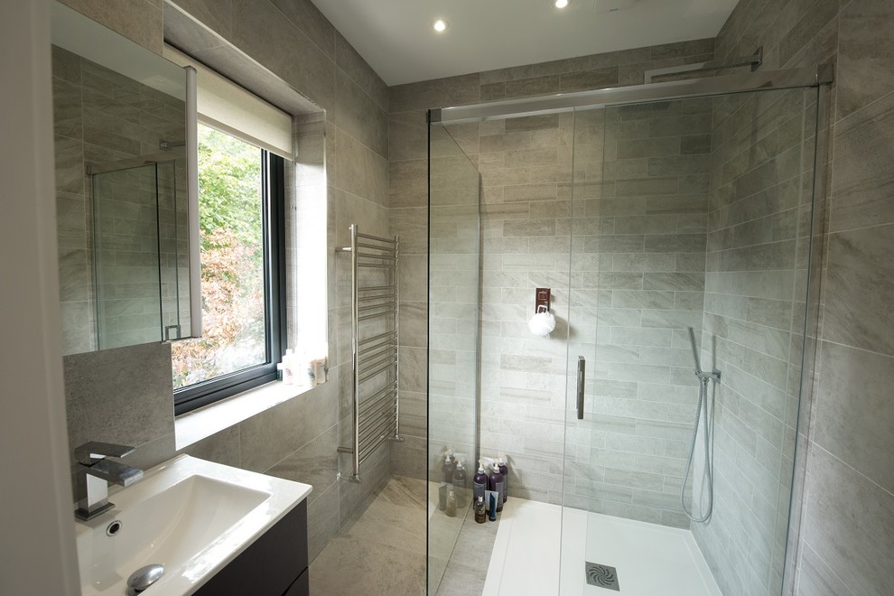 Ispirazione per una stanza da bagno con doccia moderna di medie dimensioni con doccia aperta, piastrelle grigie, piastrelle in pietra, lavabo sospeso, pavimento grigio e doccia aperta
