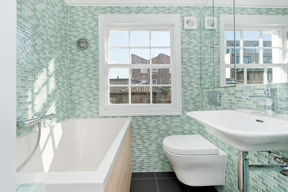 Exemple d'une petite salle de bain tendance avec un lavabo suspendu, un placard à porte plane, un bain japonais, une douche ouverte, WC suspendus, un carrelage noir, des carreaux de porcelaine, un mur blanc et un sol en carrelage de porcelaine.