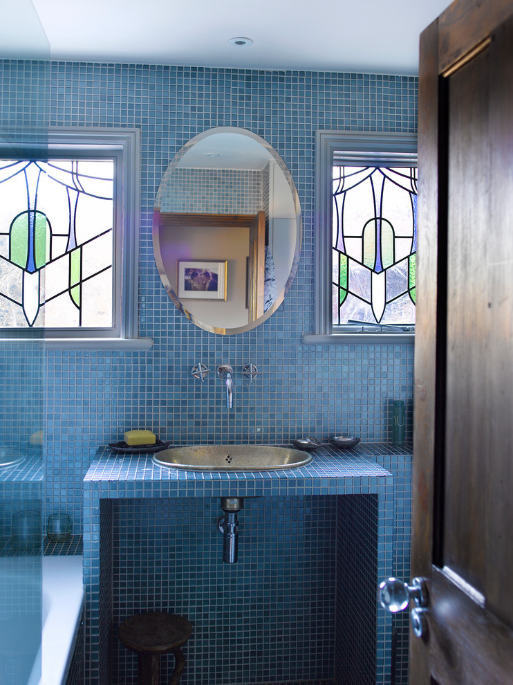 Cette image montre une salle de bain méditerranéenne avec un lavabo posé, un carrelage bleu et un mur bleu.