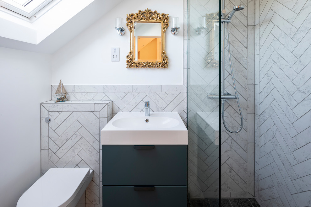 Modern inredning av ett litet vit vitt en-suite badrum, med en öppen dusch, en vägghängd toalettstol, keramikplattor, klinkergolv i keramik, svart golv, släta luckor, grå skåp, vit kakel, vita väggar, ett konsol handfat och med dusch som är öppen