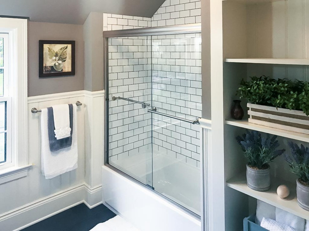 Photo of a classic family bathroom in Cleveland with shaker cabinets, black cabinets, a built-in bath, a two-piece toilet, white tiles, marble tiles, grey walls, ceramic flooring, granite worktops, black floors, a sliding door, multi-coloured worktops, double sinks, a freestanding vanity unit and wainscoting.