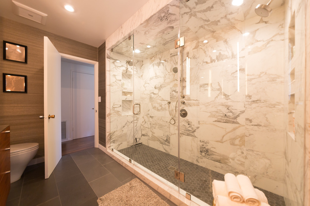 Cette photo montre une grande salle de bain principale moderne en bois clair avec une douche double, un carrelage gris, un mur marron, un placard à porte plane, un carrelage de pierre, une grande vasque, un plan de toilette en marbre, WC à poser, un sol en carrelage de céramique et un sol gris.