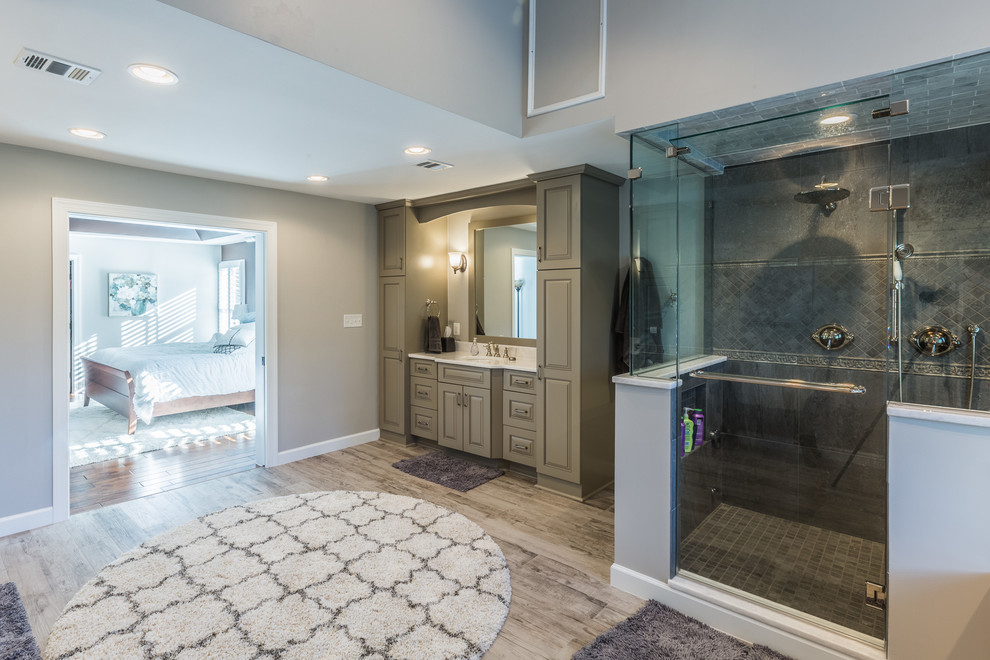 Inspiration for an expansive retro ensuite bathroom in DC Metro with raised-panel cabinets, grey cabinets, a built-in bath, a double shower, grey tiles, cement tiles, grey walls, medium hardwood flooring, a submerged sink, marble worktops, brown floors, a hinged door and white worktops.