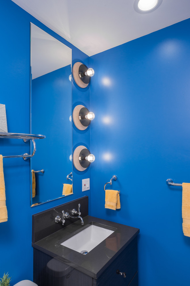 Idéer för att renovera ett mellanstort eklektiskt en-suite badrum, med släta luckor, svarta skåp, ett platsbyggt badkar, en dusch/badkar-kombination, en toalettstol med hel cisternkåpa, vit kakel, keramikplattor, blå väggar, klinkergolv i keramik, ett undermonterad handfat och bänkskiva i kalksten